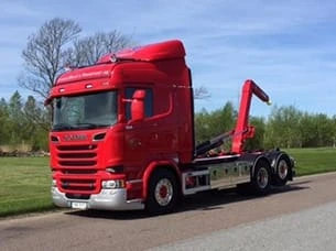 Liftdumperbil från WMT lastar avfallscontainer.
